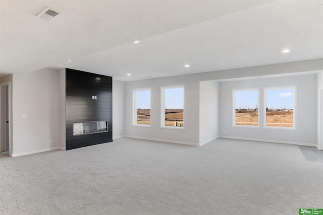 unfurnished living room with a large fireplace and light colored carpet