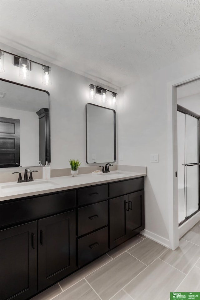 bathroom with vanity, a textured ceiling, and walk in shower