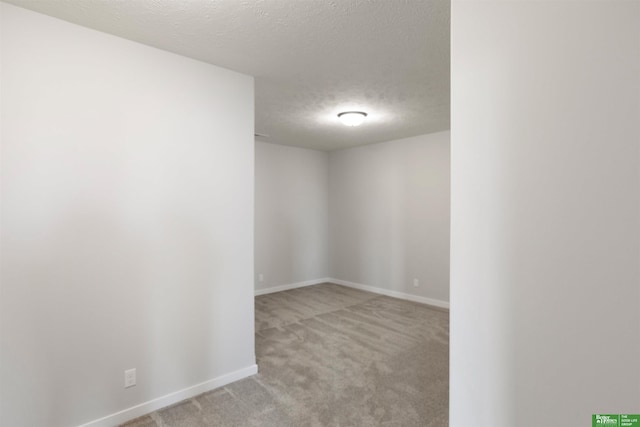 unfurnished room featuring light colored carpet and a textured ceiling