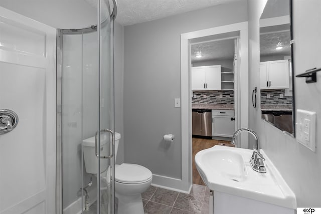 bathroom with tasteful backsplash, vanity, walk in shower, and a textured ceiling