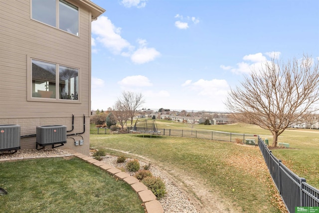 view of yard featuring central AC and a trampoline