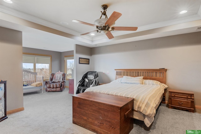 bedroom featuring crown molding, light carpet, ceiling fan, and a tray ceiling