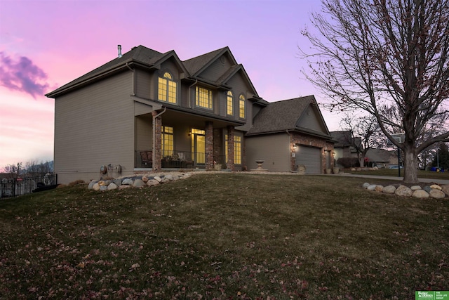 view of front of home with a garage, a lawn, and a porch