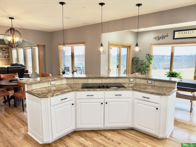 kitchen featuring white cabinetry, dark stone countertops, and decorative light fixtures