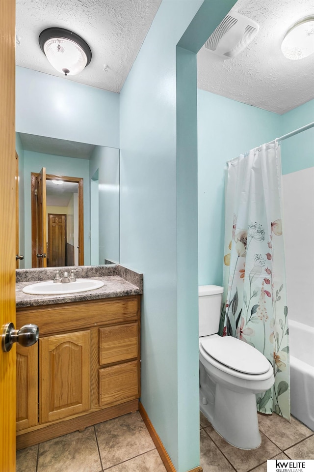 full bathroom featuring shower / tub combo with curtain, vanity, a textured ceiling, tile patterned floors, and toilet