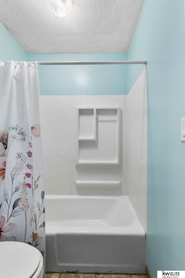 bathroom with shower / bathtub combination with curtain, a textured ceiling, and toilet