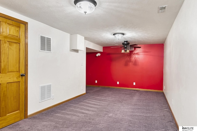 unfurnished room featuring ceiling fan, a textured ceiling, and dark carpet