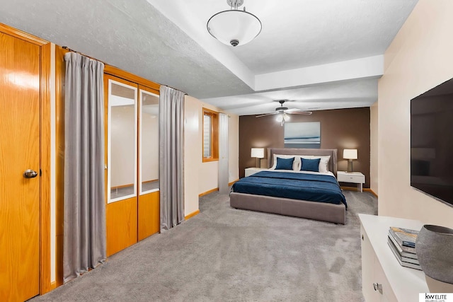 bedroom featuring ceiling fan, light colored carpet, and a textured ceiling