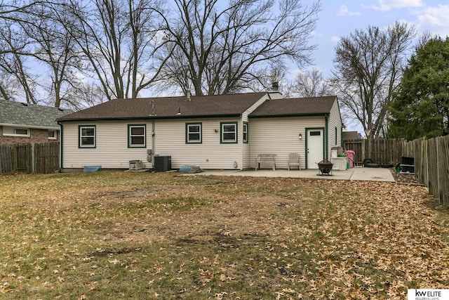 rear view of house with central AC, a patio, and a lawn