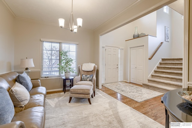 living room with hardwood / wood-style floors, a notable chandelier, and ornamental molding