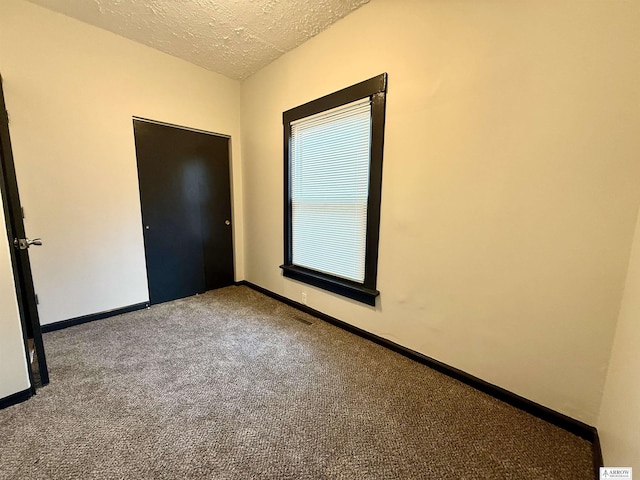 spare room with carpet floors and a textured ceiling