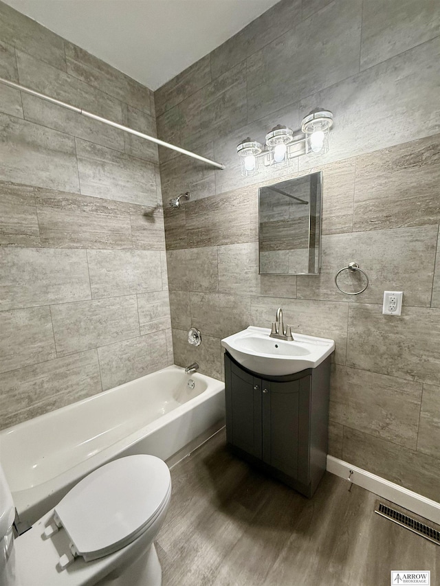 full bathroom with vanity, hardwood / wood-style flooring, toilet, and tiled shower / bath combo