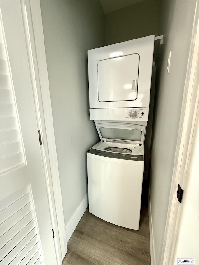 clothes washing area with stacked washer / drying machine and hardwood / wood-style flooring