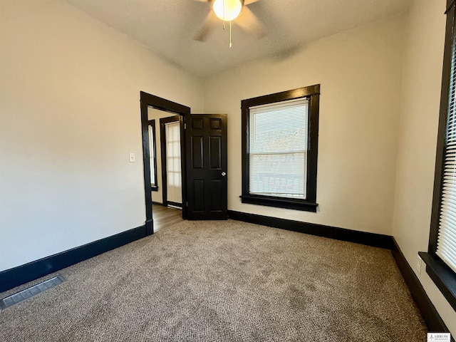 carpeted spare room featuring ceiling fan