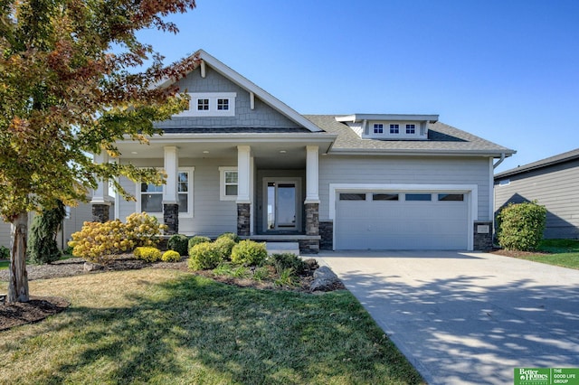 craftsman house with a garage, a front yard, and a porch