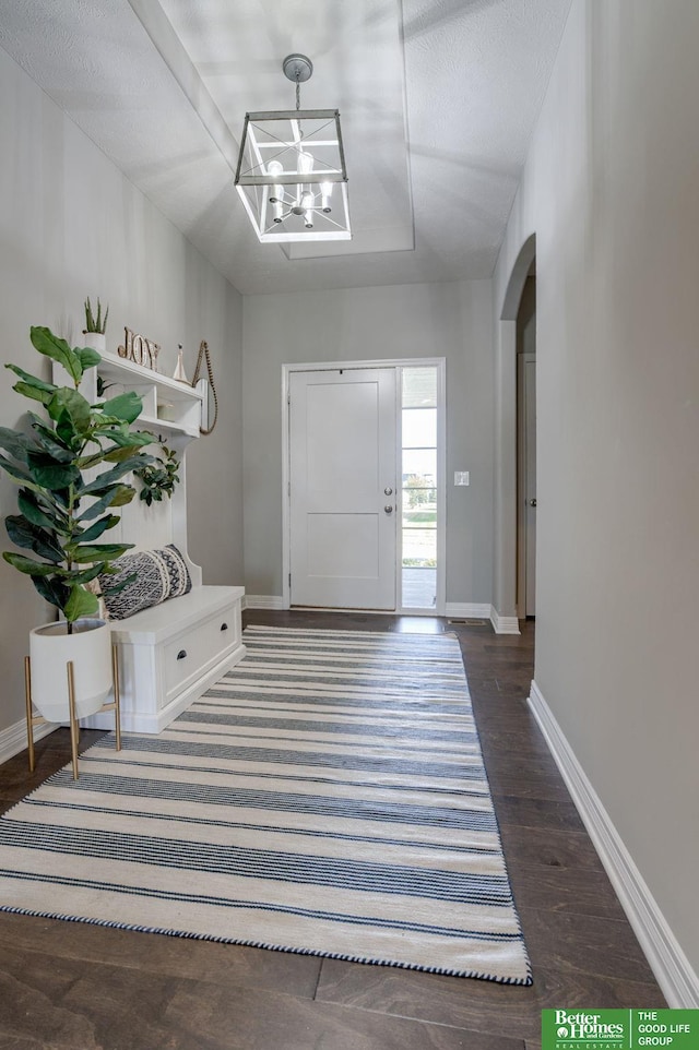 entrance foyer featuring dark hardwood / wood-style floors and a notable chandelier