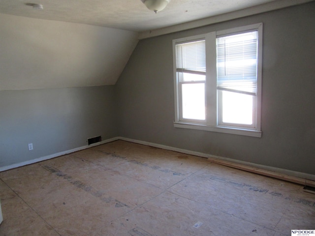 bonus room featuring lofted ceiling and visible vents