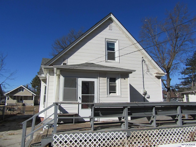 rear view of property featuring a sunroom and a wooden deck