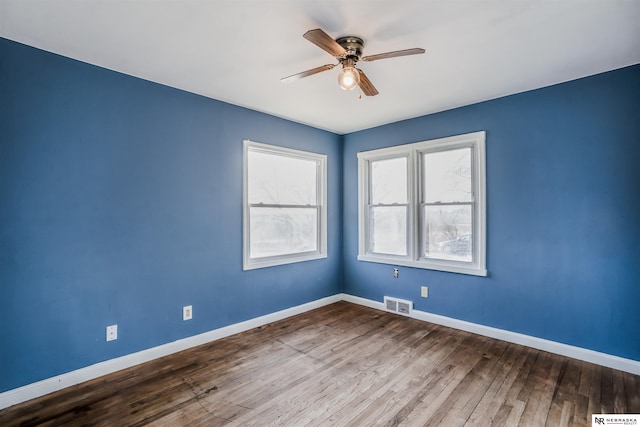 spare room with hardwood / wood-style flooring and ceiling fan