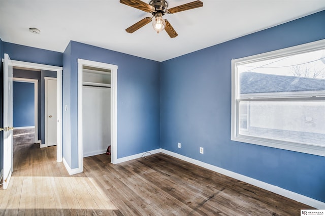 unfurnished bedroom featuring hardwood / wood-style flooring, ceiling fan, and a closet