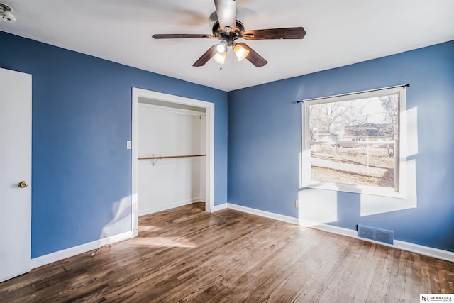 unfurnished bedroom featuring hardwood / wood-style floors, a closet, and ceiling fan