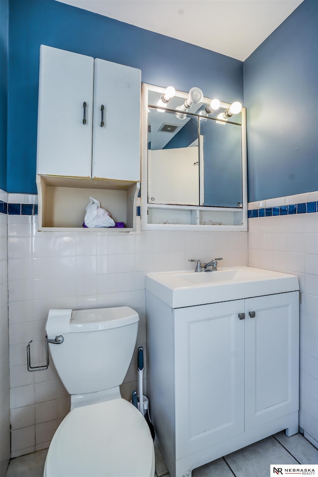 bathroom featuring vanity, tile walls, tile patterned floors, and toilet