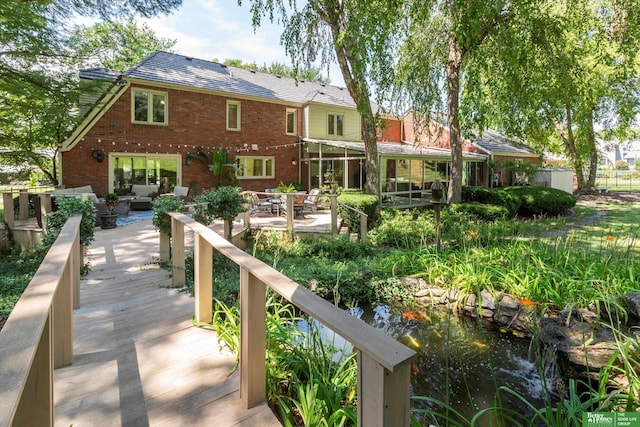 back of house featuring an outdoor living space, a patio, and a deck