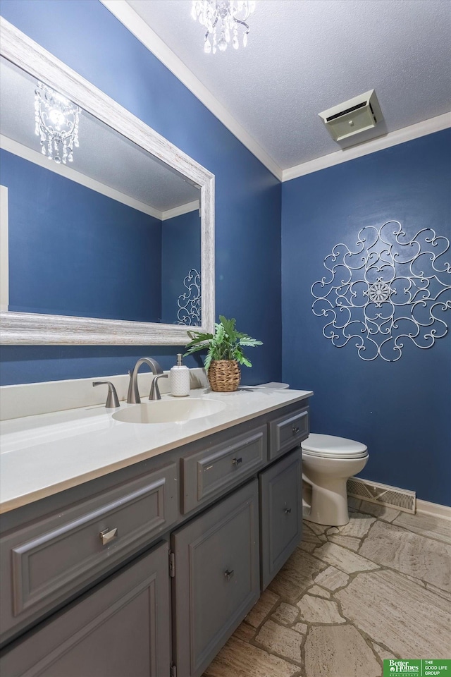 bathroom with vanity, a notable chandelier, ornamental molding, a textured ceiling, and toilet