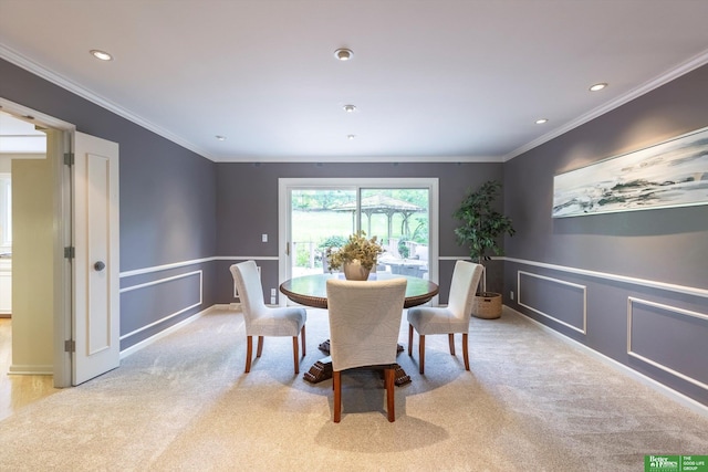 dining area featuring crown molding and light colored carpet