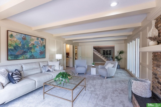 carpeted living room with beam ceiling