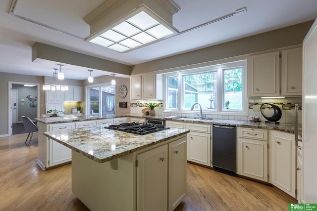 kitchen featuring sink, white cabinetry, decorative light fixtures, a kitchen island, and backsplash