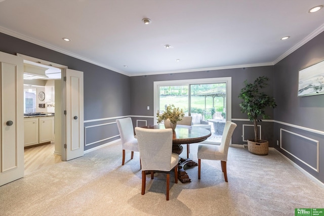 dining space featuring crown molding and light colored carpet