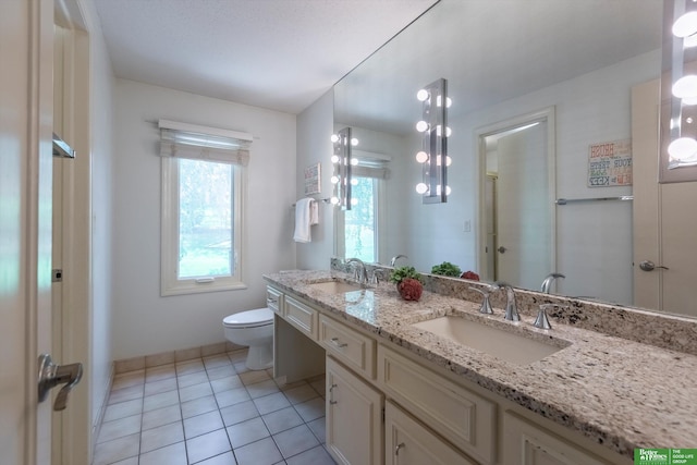 bathroom with tile patterned flooring, vanity, and toilet