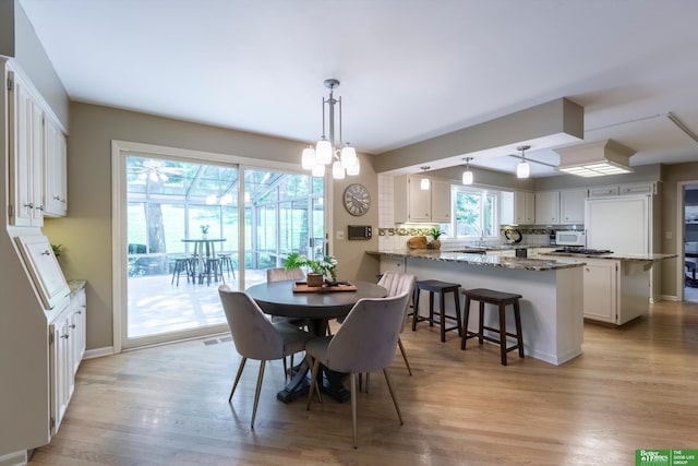 dining area with a chandelier and light hardwood / wood-style flooring