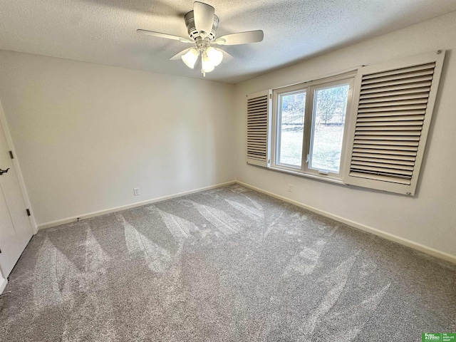 carpeted empty room featuring ceiling fan and a textured ceiling