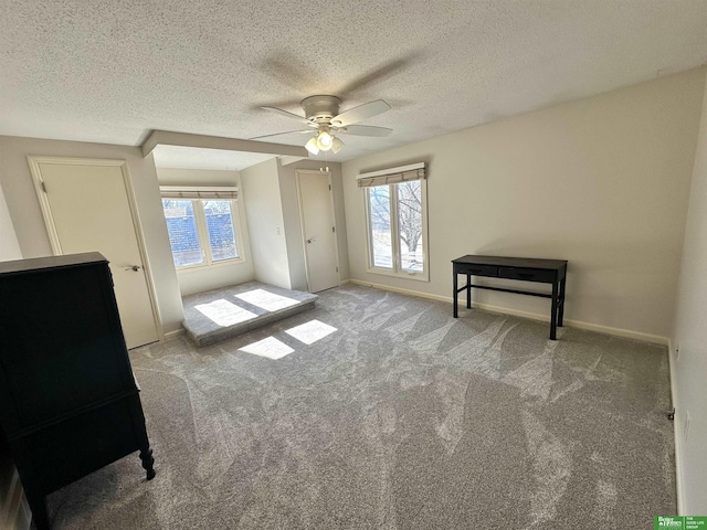 carpeted spare room featuring ceiling fan and a textured ceiling