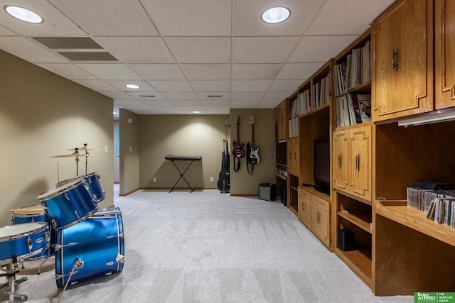 living area featuring light carpet and a paneled ceiling