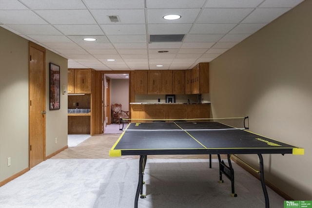 recreation room with light colored carpet and a drop ceiling