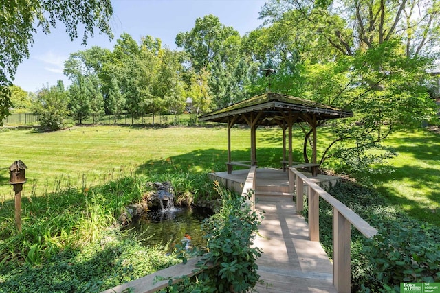 surrounding community featuring a gazebo, a water view, and a lawn