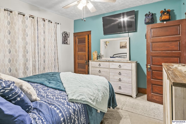 bedroom with ceiling fan and a textured ceiling