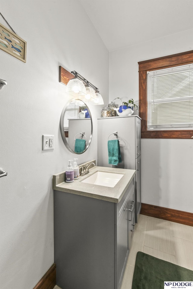 bathroom with vanity, tile patterned flooring, and lofted ceiling