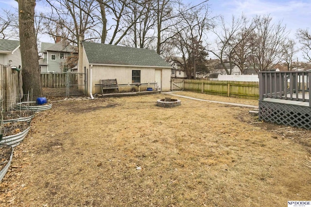 view of yard with a deck and a fire pit