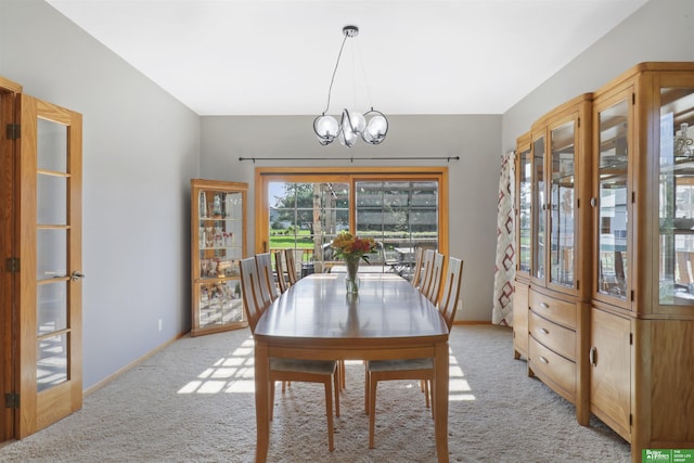 dining room featuring light colored carpet and a notable chandelier