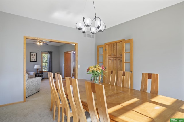 carpeted dining area featuring an inviting chandelier