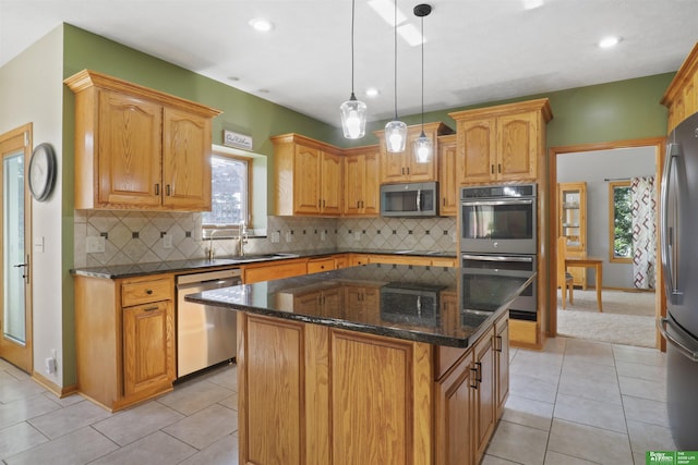 kitchen with a kitchen island, light tile patterned flooring, appliances with stainless steel finishes, and pendant lighting