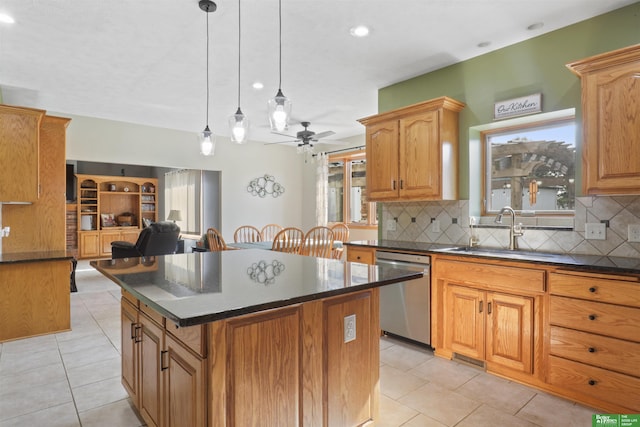 kitchen featuring pendant lighting, sink, light tile patterned floors, a kitchen island, and stainless steel dishwasher