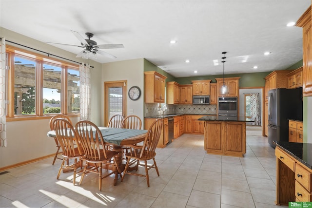 tiled dining space featuring ceiling fan and sink