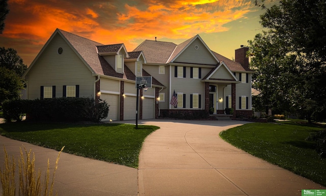 view of front of home with a garage and a lawn