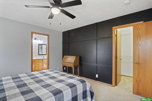 carpeted bedroom featuring connected bathroom, ceiling fan, sink, and a textured ceiling