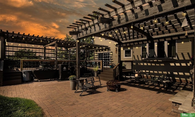 patio terrace at dusk featuring a pergola and an outdoor fire pit